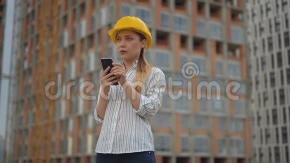 一位女工程师的特写肖像女孩手里拿着一部手机键入一条短信4克视频的预览图