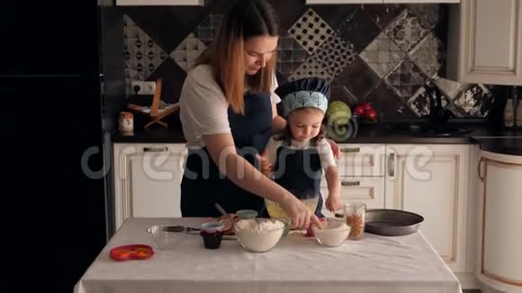 妈妈和小女儿一起做面团他们吃糖舔手指视频的预览图