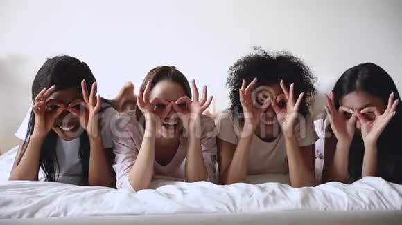 有趣的多民族女孩在床上玩双筒望远镜视频的预览图