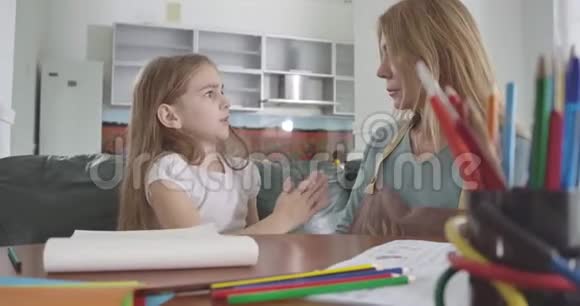 可爱的白种女孩让妈妈在作业后休息母亲拒绝女儿离开年轻女子抱视频的预览图
