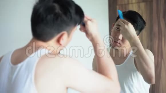 年轻男性在浴室照镜子时梳头视频的预览图