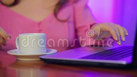 女人的手拿着一杯咖啡用电脑工作视频的预览图