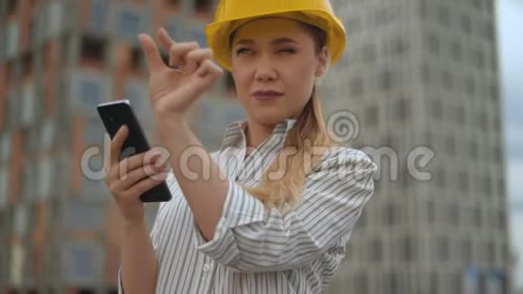 一位女工程师的特写肖像女孩手里拿着一部智能手机用一克贺礼工作4克视频的预览图