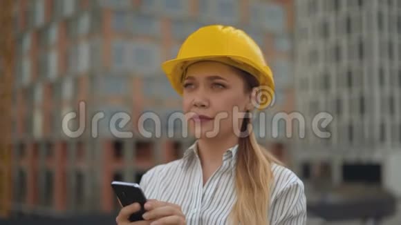 一位女工程师的特写肖像女孩手里拿着一部手机键入一条短信4K视频的预览图