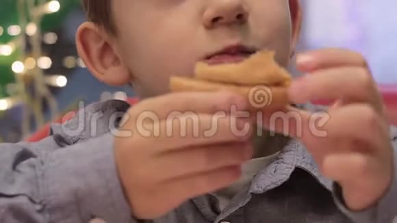 在沙发上的咖啡馆里吃汉堡的男孩视频的预览图