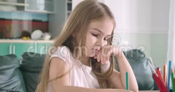 侧视特写的悲伤白种人女孩依靠手指和写作结果的练习本聪明的孩子视频的预览图
