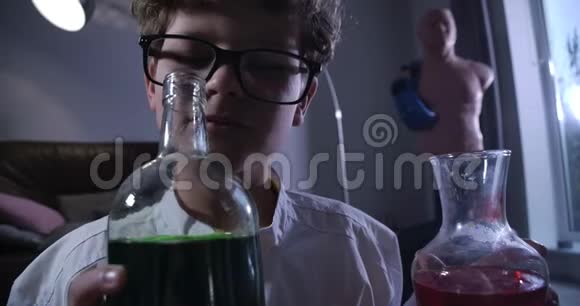 白种人青少年化学家嗅化学品的特写镜头穿着实验室外套的卷发男孩看着装满瓶子视频的预览图
