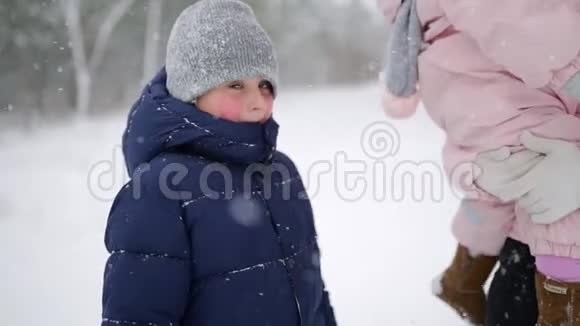 带着一家人走在冬天的森林里在下雪的情况下度假父亲母亲儿子和女儿视频的预览图