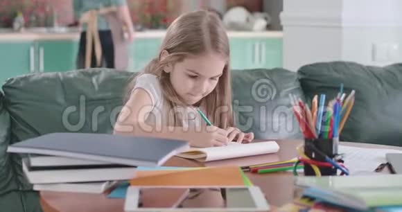 可爱的白种人女学生在练习本和思考中写作的肖像聪明的女孩在家做作业视频的预览图