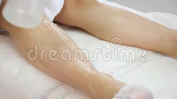 女性双手在医疗中心用凝胶和激光头滑动腿部视频的预览图