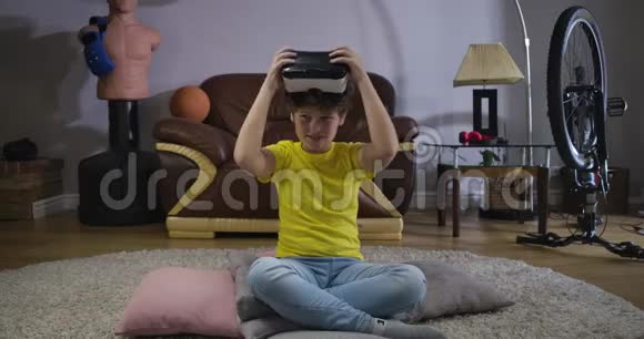 微笑的白种人男孩穿着休闲服装戴上VR耳机的肖像可爱的孩子在尝试他的礼物虚拟现实视频的预览图