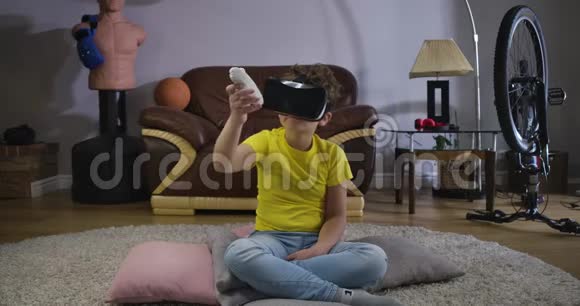 小男孩在VR谷歌移动手与遥控器和看方向的控制器白人小孩视频的预览图