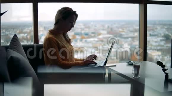 年轻的女商人正在一家城市咖啡馆里用笔记本电脑工作视频的预览图