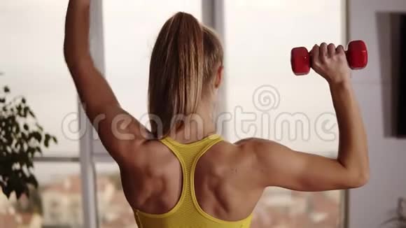 强壮的健身妇女举起哑铃同时做二头肌练习享受训练漂亮的运动女性视频的预览图