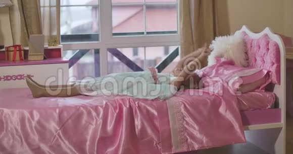 小白种人女孩躺在粉红色的床上打手势说话积极的孩子周末在家休息视频的预览图