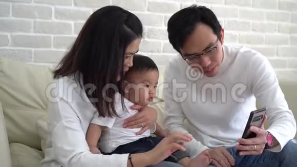 快乐的亚洲家庭在家打视频电话视频的预览图