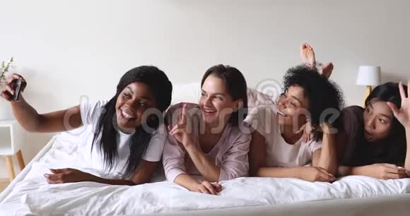 快乐的多民族女人穿睡衣自拍庆祝睡衣派对视频的预览图