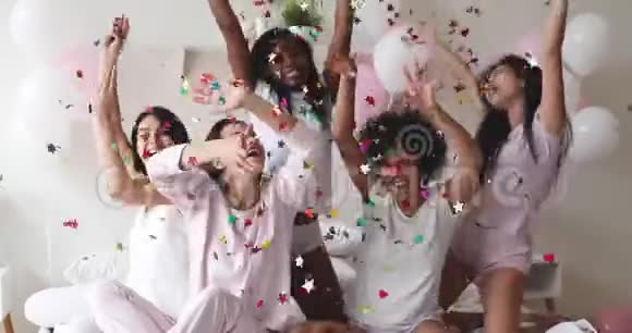 高兴兴奋的年轻女士庆祝睡衣派对掉落纸屑视频的预览图