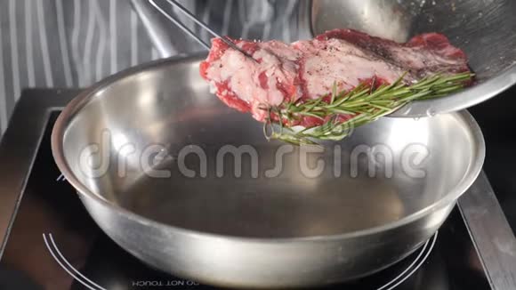 把一块肉放在煎锅上厨师在餐厅厨房做饭快关门双手合拢准备牛排视频的预览图