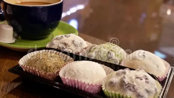 热咖啡和粘米糕在桌子上的运动反映人们走过的背景视频的预览图
