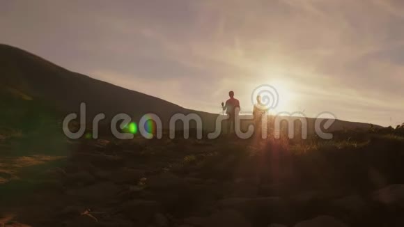 活方式的浪漫几个游客在夕阳的照耀下沿着山道走视频的预览图