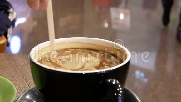 人们放奶油和搅拌咖啡的动作视频的预览图