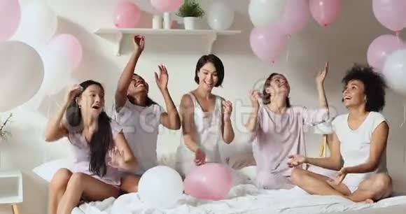 积极的多民族女孩玩气球庆祝睡衣派对视频的预览图