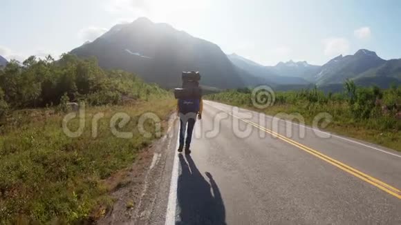 年轻女子背包客搭便车在路上散步风景优美视频的预览图