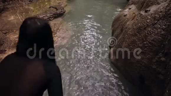 一位年轻女子暑假在河里跳跃和游泳的后景视频的预览图