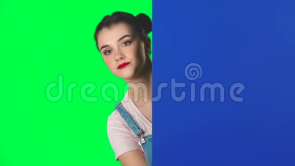 女人从蓝色空白的标语牌后面往外看对着自己指指点点动作缓慢视频的预览图