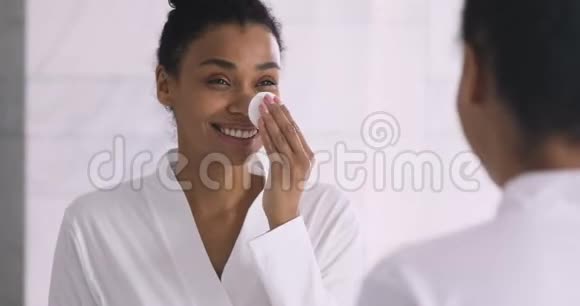 健康微笑的非洲女人拿着棉垫清洁皮肤视频的预览图