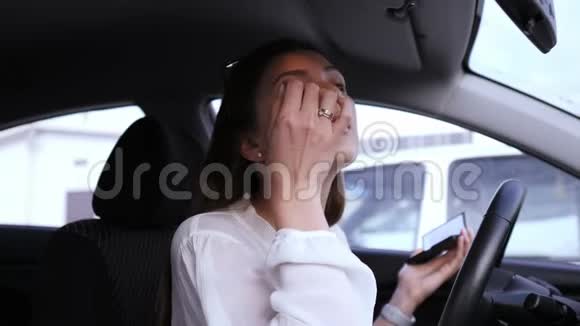 美和化妆品的概念一个漂亮的女司机在车里的肖像把阴影涂在眼睛上视频的预览图