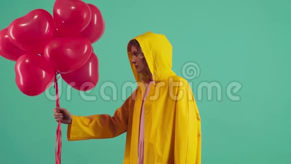 美丽的年轻女子绿色背景上有心形气球情人节庆祝活动视频的预览图