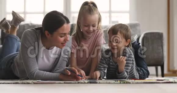年轻的妈妈教小孩学画画在地板上玩视频的预览图