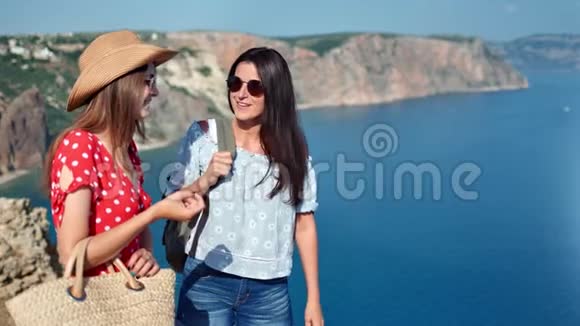 两个旅行的女朋友在聊天欣赏美丽的海景度假视频的预览图