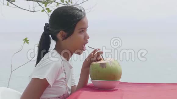 美丽的亚洲女人喜欢在度假胜地喝新鲜的椰子汁视频的预览图