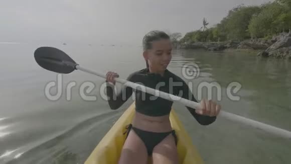年轻女子喜欢在海里划艇在夏天玩划艇视频的预览图