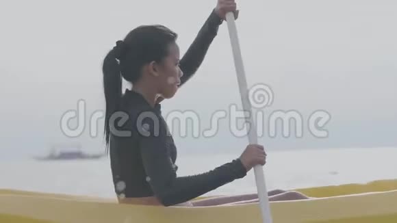 年轻而强壮的女人在平静的海洋中皮划艇在热带度假胜地夏季视频的预览图