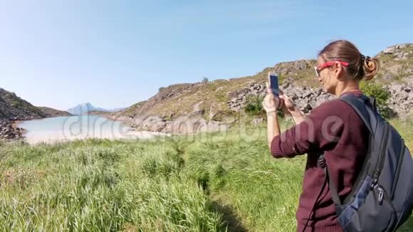 年轻的女旅行者用她的智能手机拍照视频的预览图