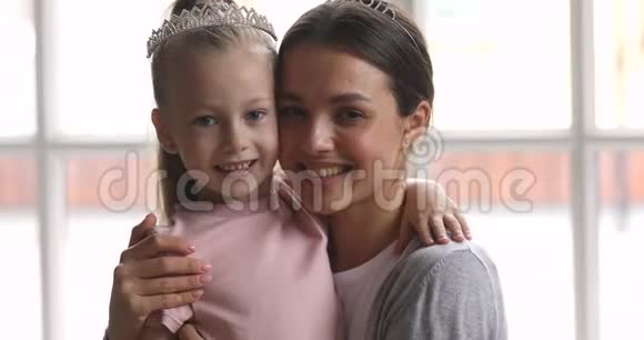 爱妈妈拥抱戴着皇冠的可爱小女儿视频的预览图