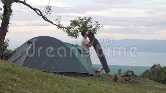 一个人试图用嘴吹露营的空气床上的空气视频的预览图