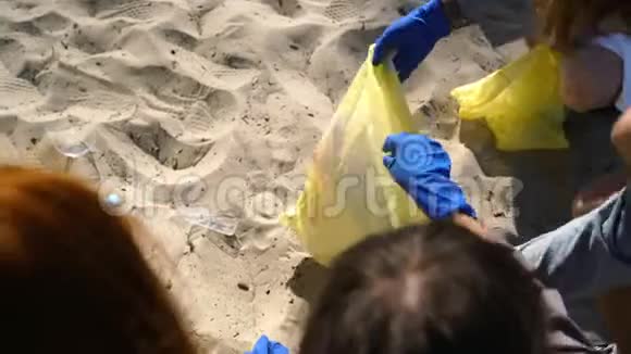 一群积极分子朋友在海滩上收集塑料垃圾近景视频的预览图