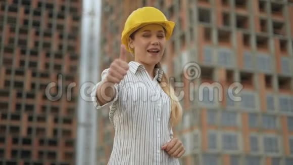 竖起大拇指自信快乐的女建筑工人戴着安全帽看着镜头竖起大拇指视频的预览图