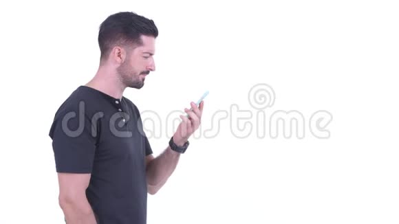 年轻英俊的留胡子男子在使用电话时等待的侧写视图视频的预览图