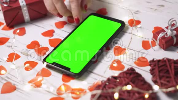 情人节一个女人用一部带有绿色屏幕的智能手机特写视频的预览图