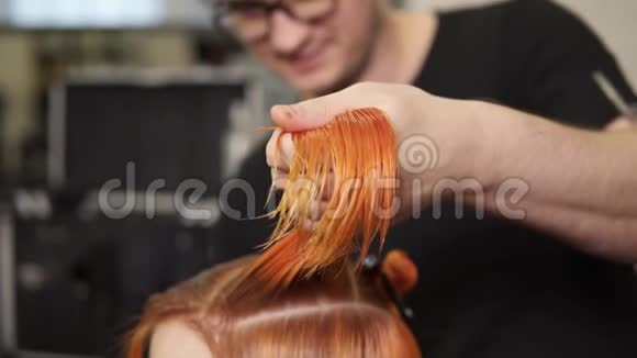 时尚的男理发师在美容院剪女头发手里拿着一缕头发年轻女子视频的预览图