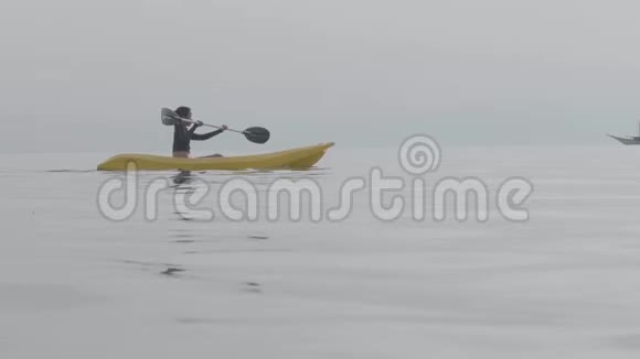 暑假女人独自在宁静的海洋里皮划艇水上运动视频的预览图