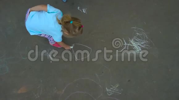 女孩在沥青上画画视频的预览图