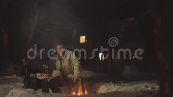 年轻夫妇在火边喝啤酒视频的预览图