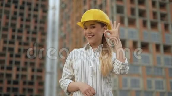 好的自信的女工程师戴着安全帽看着摄像机露出一个手势好吗视频的预览图